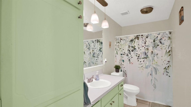 bathroom featuring visible vents, toilet, vanity, a shower with curtain, and tile patterned floors