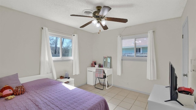 bedroom with a textured ceiling, ceiling fan, light tile patterned floors, and baseboards