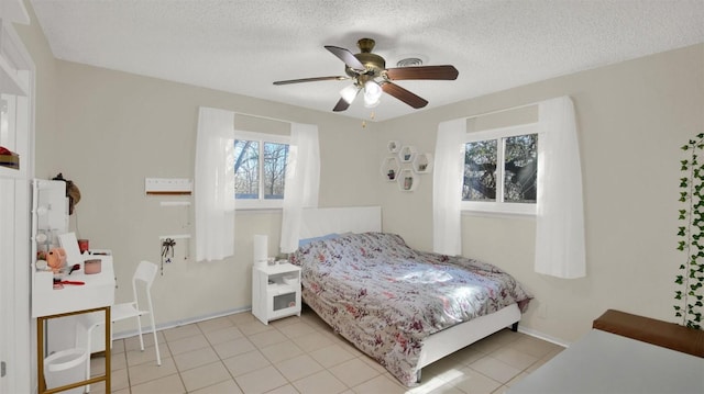 bedroom featuring a textured ceiling, ceiling fan, and light tile patterned floors