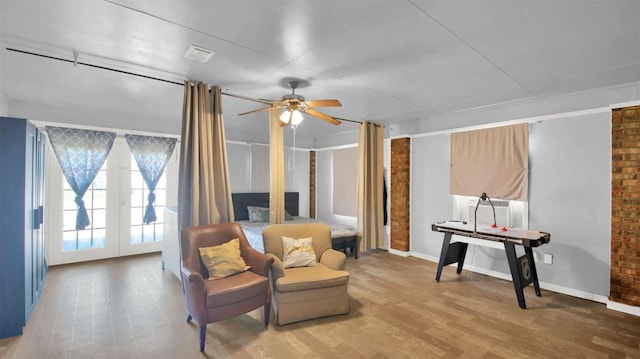 living area with baseboards, visible vents, ceiling fan, and wood finished floors