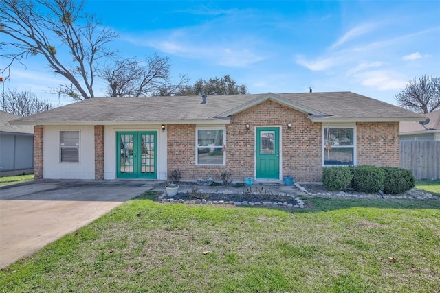 single story home featuring a shingled roof, a front yard, french doors, and brick siding