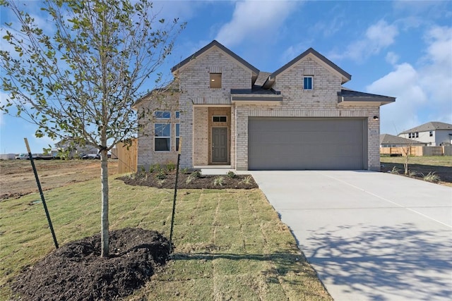 view of front of property featuring a garage, a front yard, concrete driveway, and brick siding