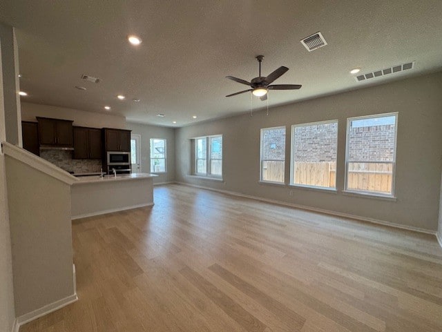2705 Sage Ranch Dr Unit 6, Leander, TX 78641 - unfurnished living room with light wood-type flooring, recessed lighting, ceiling fan, and a textured ceiling