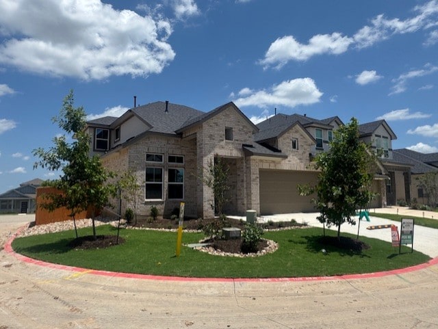 2705 Sage Ranch Dr Unit 6, Leander, TX 78641 - view of front of property featuring a front yard, driveway, stone siding, and brick siding