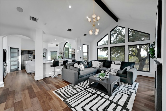 living room with high vaulted ceiling, a notable chandelier, dark wood-type flooring, visible vents, and beam ceiling