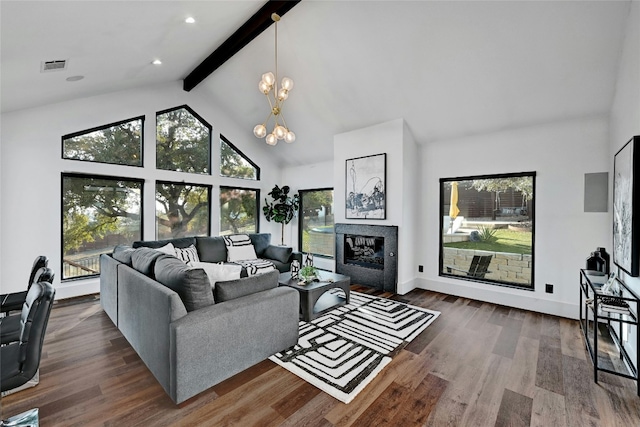 living room with a notable chandelier, dark wood-style flooring, visible vents, beamed ceiling, and a glass covered fireplace