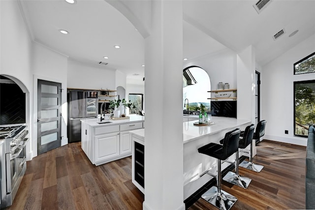 kitchen with visible vents, high end stainless steel range, light countertops, white cabinetry, and open shelves