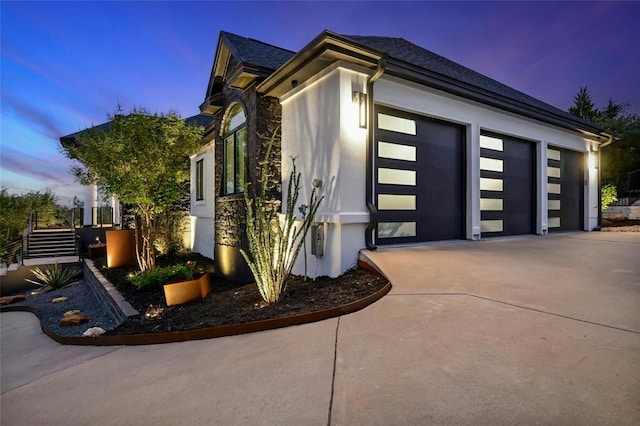 view of home's exterior featuring concrete driveway, an attached garage, and stucco siding