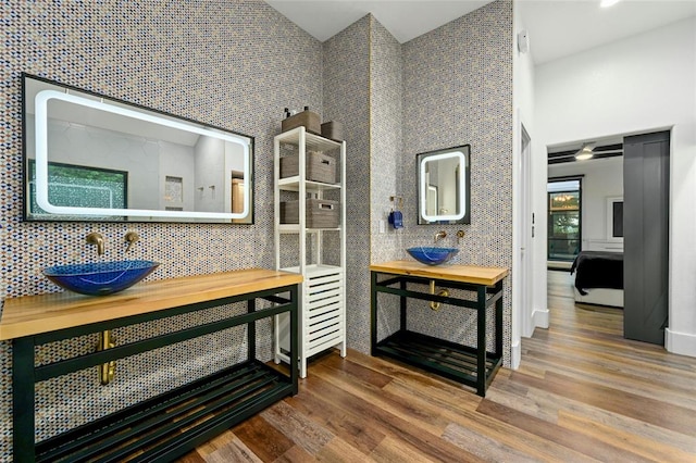 full bathroom with wood finished floors, ensuite bath, and a sink