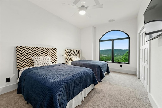 bedroom featuring light carpet, a ceiling fan, visible vents, baseboards, and a closet