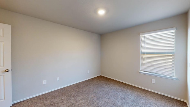 unfurnished room with carpet floors and baseboards