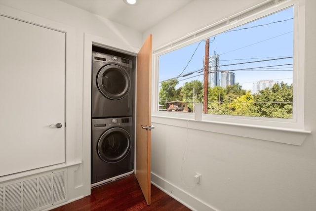 1201 Taylor St, Austin, TX 78702 - laundry room with stacked washer / drying machine, dark wood finished floors, and baseboards