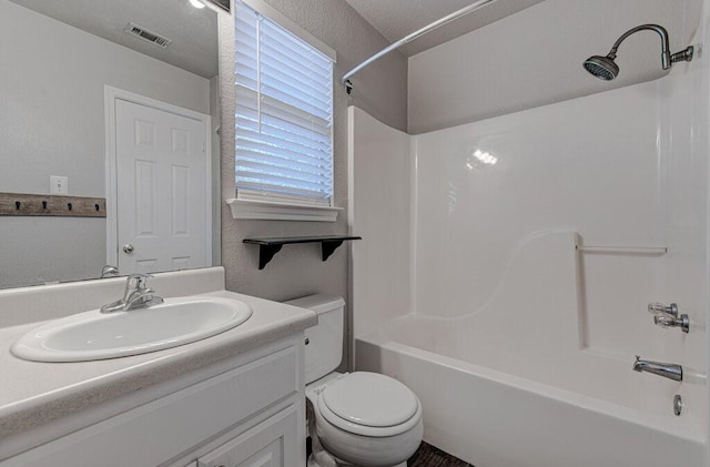 bathroom featuring visible vents, a textured wall, shower / bathing tub combination, toilet, and vanity