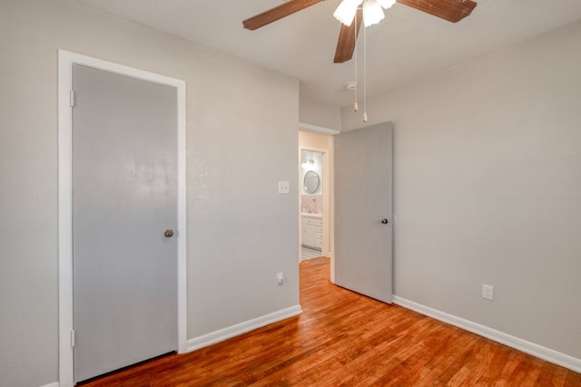 unfurnished bedroom with a ceiling fan, baseboards, and wood finished floors