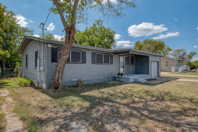 view of front of house featuring an attached garage, fence, and a front lawn