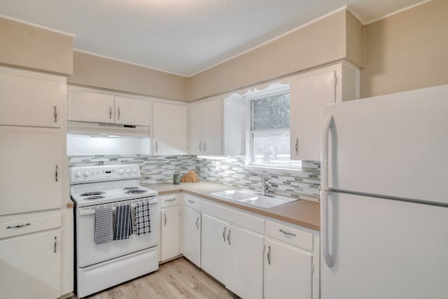 kitchen with under cabinet range hood, white appliances, a sink, white cabinets, and light countertops