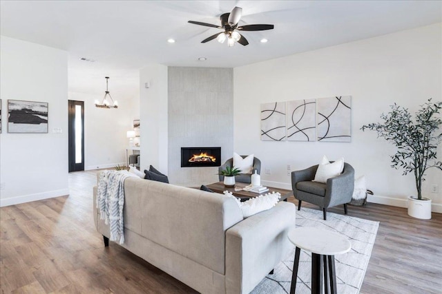 15400 Fm 1826, Austin, TX 78737 - living area with a tile fireplace, light wood-style flooring, ceiling fan, recessed lighting, and a chandelier