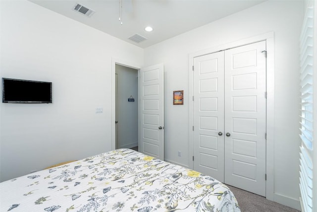 carpeted bedroom with baseboards, visible vents, and a closet