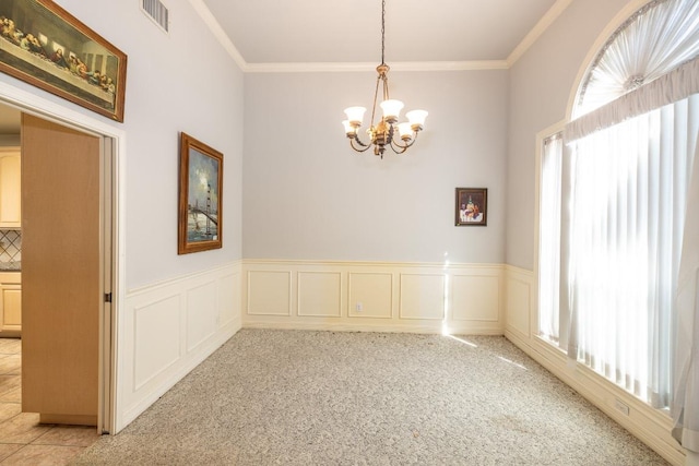 spare room featuring ornamental molding, visible vents, and a healthy amount of sunlight