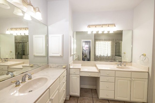 bathroom featuring a shower stall, two vanities, a sink, and tile patterned floors