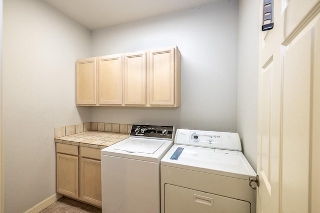 laundry room with cabinet space, baseboards, and independent washer and dryer