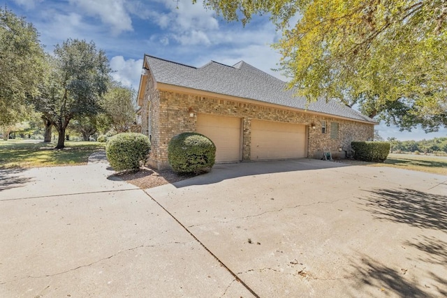 view of home's exterior featuring driveway, brick siding, an attached garage, and a shingled roof