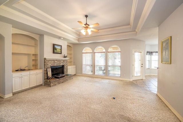 unfurnished living room featuring built in features, a raised ceiling, light colored carpet, and ornamental molding