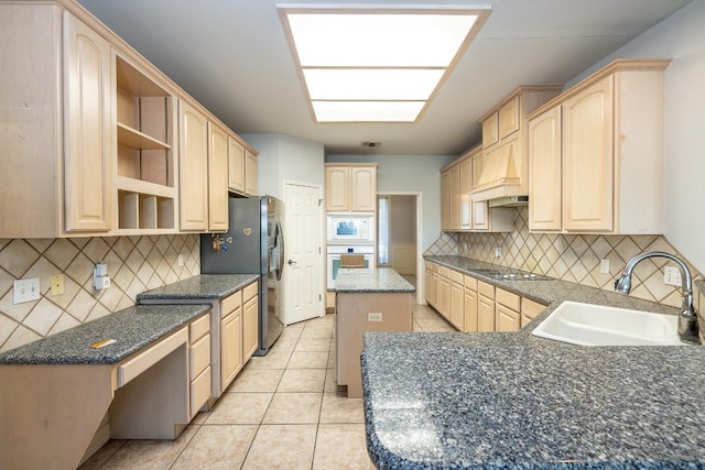 kitchen with white appliances, a center island, light brown cabinets, open shelves, and a sink