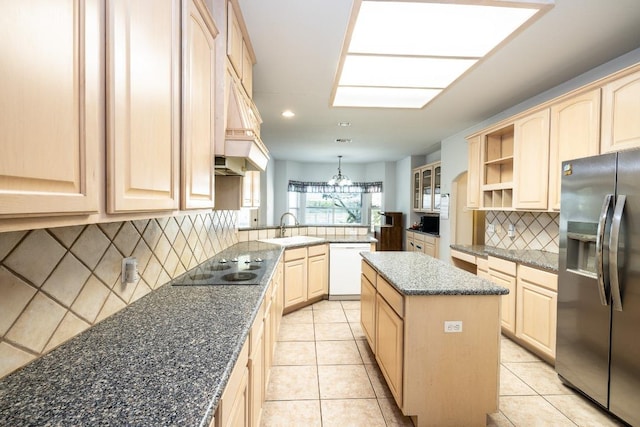 kitchen with a center island, a peninsula, white dishwasher, light brown cabinetry, and stainless steel refrigerator with ice dispenser