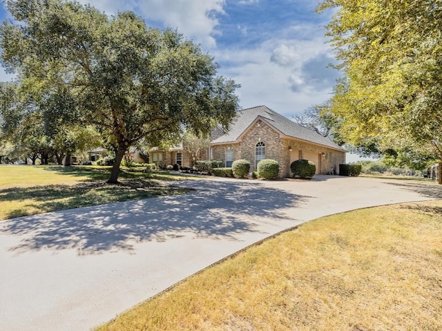 view of front of property with an attached garage, driveway, and a front lawn