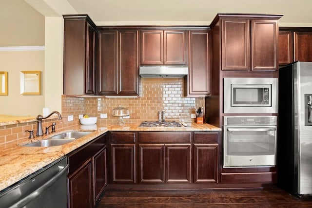 kitchen with under cabinet range hood, tasteful backsplash, stainless steel appliances, and a sink