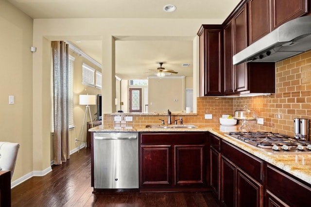 kitchen with under cabinet range hood, stainless steel appliances, a peninsula, a sink, and dark brown cabinets