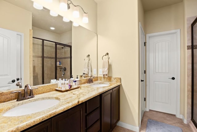 full bathroom featuring double vanity, a stall shower, and a sink