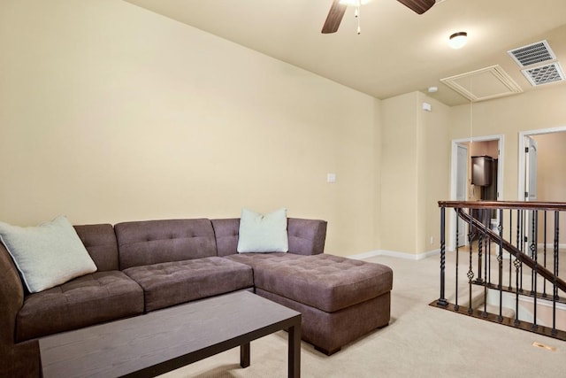 carpeted living room with attic access, visible vents, baseboards, and a ceiling fan