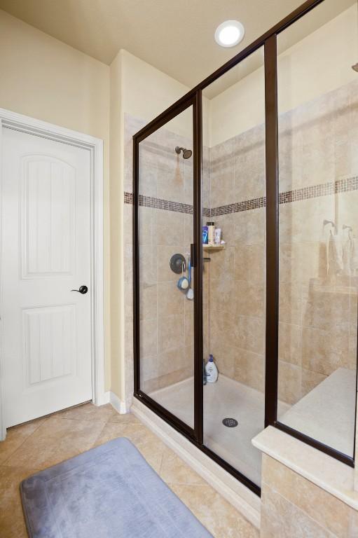 full bathroom featuring a stall shower and tile patterned flooring