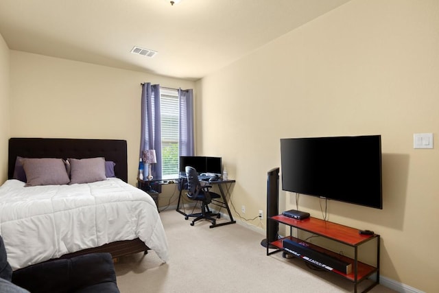 bedroom with baseboards, visible vents, and light colored carpet