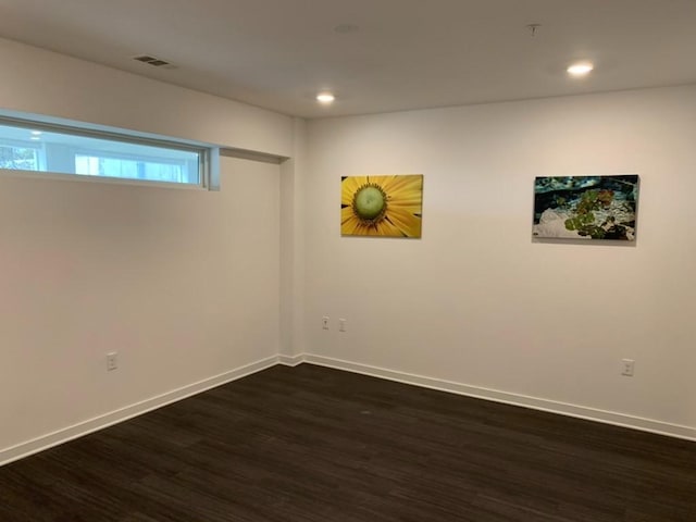 spare room featuring dark wood-style flooring, recessed lighting, visible vents, and baseboards