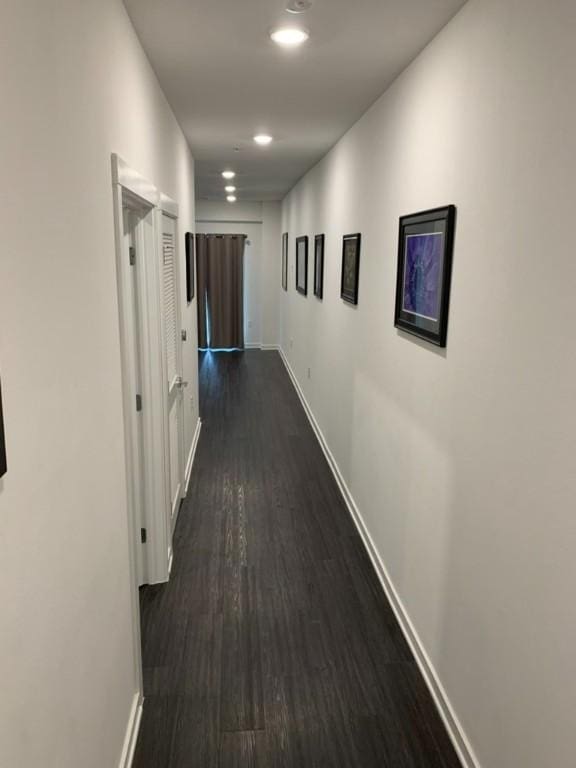 hall with dark wood-type flooring, recessed lighting, and baseboards