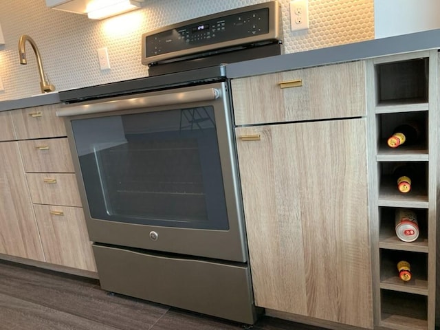 4361 S Congress Ave Unit 304, Austin, TX 78745 - kitchen view of electric range, light brown cabinets, dark wood-style floors, and modern cabinets