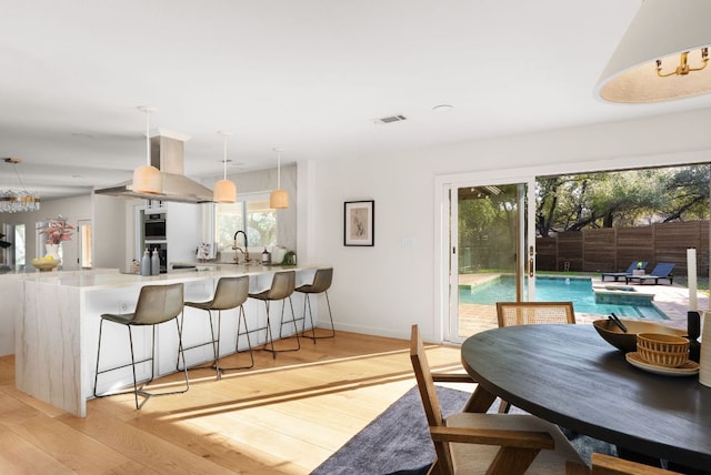 dining room with visible vents, light wood-style flooring, and baseboards