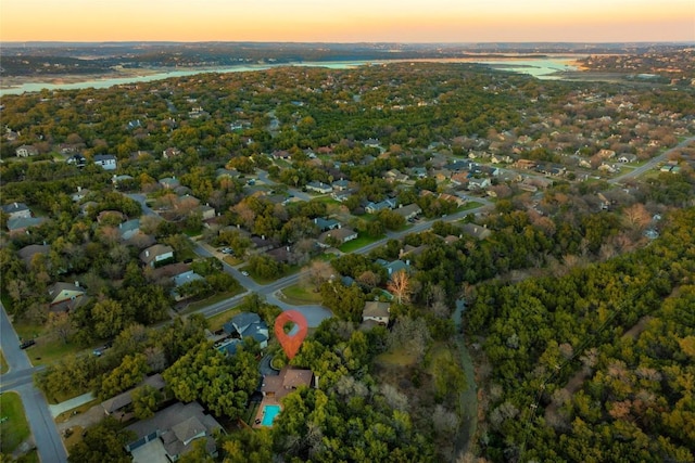 aerial view at dusk featuring a water view