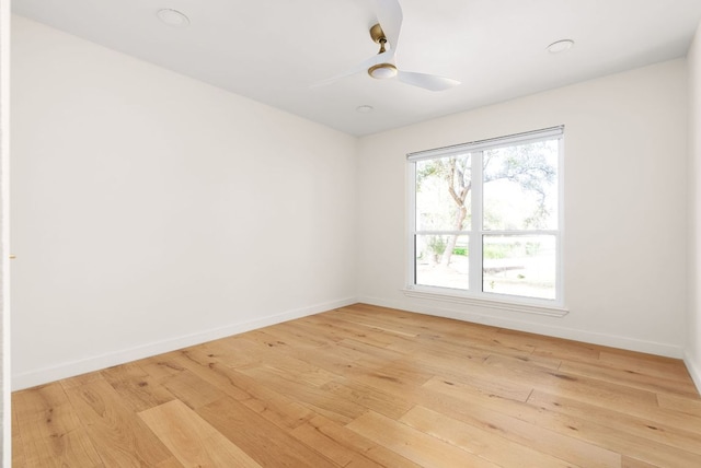 empty room featuring light wood-style flooring, baseboards, and a ceiling fan