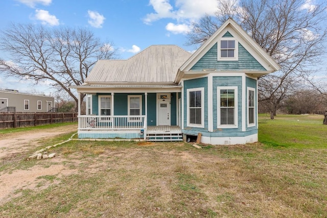 view of front of house featuring metal roof, a porch, fence, crawl space, and a front lawn