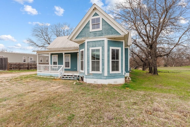 view of front of house featuring a front yard, crawl space, covered porch, and fence