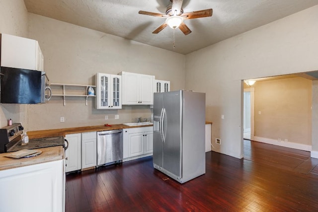 kitchen with white cabinets, dark wood finished floors, glass insert cabinets, stainless steel appliances, and a sink