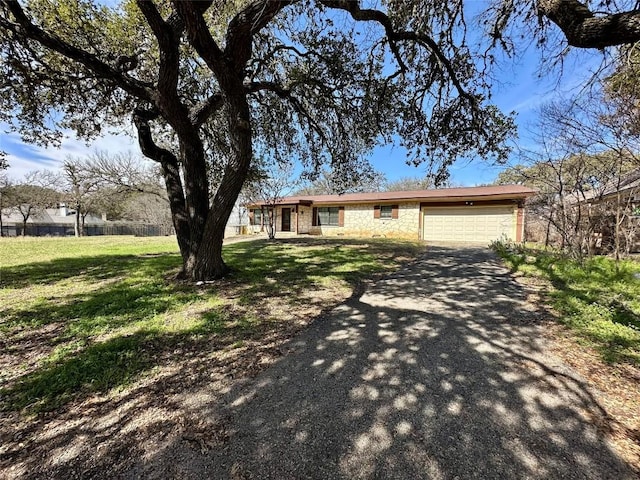 ranch-style house with stone siding, aphalt driveway, an attached garage, and a front yard