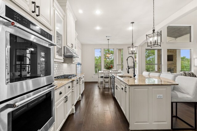 3804 Venezia Vw, Leander, TX 78641 - kitchen featuring recessed lighting, appliances with stainless steel finishes, a chandelier, white cabinets, and decorative backsplash