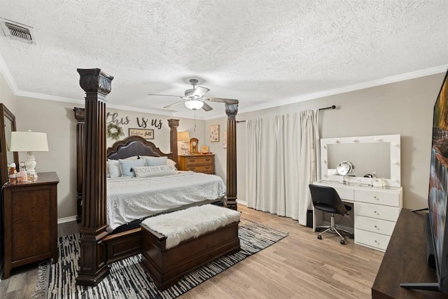 bedroom featuring ornamental molding, light wood-type flooring, visible vents, and a ceiling fan