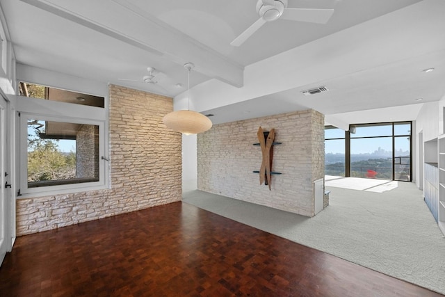 spare room featuring ceiling fan, visible vents, dark wood-style flooring, and beamed ceiling