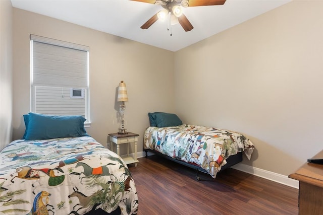 bedroom with dark wood-type flooring, a ceiling fan, and baseboards